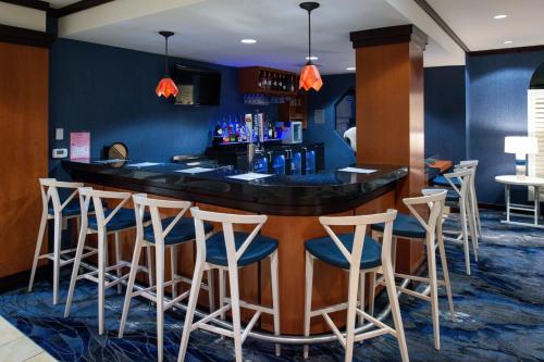 a bar in a restaurant with white stools at Fairfield Inn & Suites Santa Cruz - Capitola in Capitola