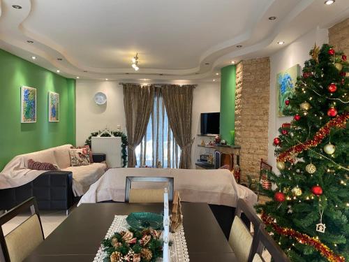 un salon avec un sapin de Noël et une table dans l'établissement Aleksandras Διαμερίσματα, à Ioannina