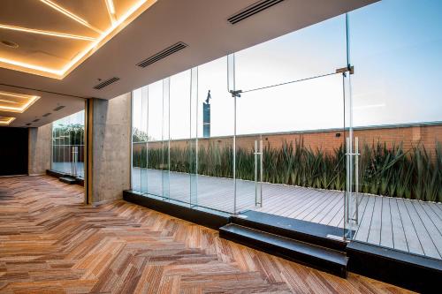 a lobby with glass walls and a wooden floor at Four Points by Sheraton Puebla in Puebla