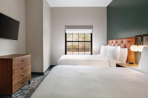 a hotel room with two beds and a flat screen tv at Four Points by Sheraton Raleigh Arena in Raleigh