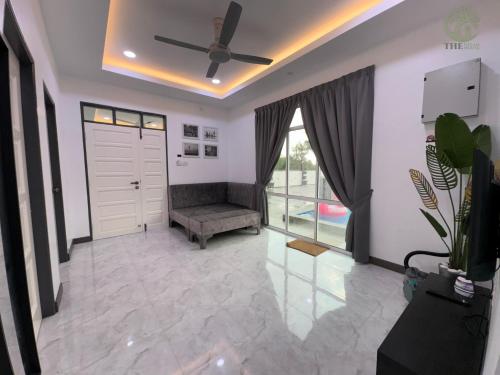 a living room with a door and a couch at The Gelam House in Kampong Telaga Papan