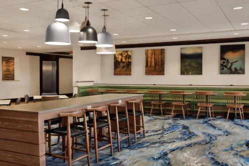 a waiting room with a large table and stools at Fairfield Inn & Suites by Marriott Tupelo in Tupelo
