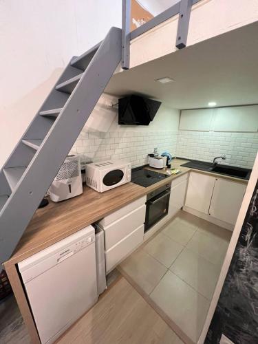 une cuisine avec des placards blancs et un escalier. dans l'établissement Appartement en centre-ville, proche gares, à Nice