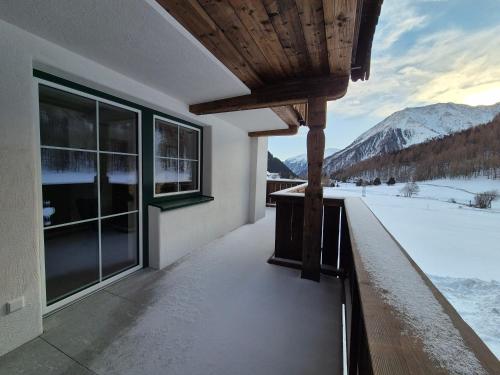 a house with a balcony with a view of the mountains at HAGGNER Hideaway in Sankt Sigmund im Sellrain