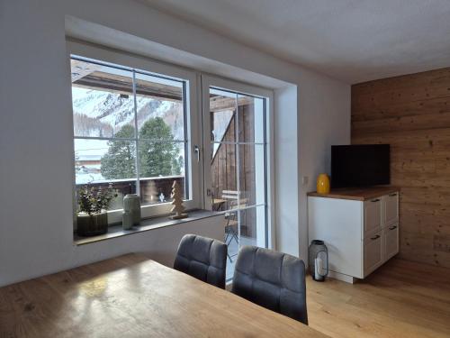 a dining room with a table and a large window at HAGGNER Hideaway in Sankt Sigmund im Sellrain