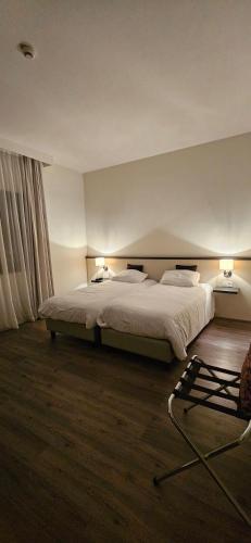 - une chambre dotée d'un grand lit avec deux lampes dans l'établissement La Grande Baie, à Bourgneuf-en-Retz