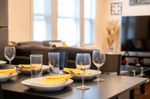 a table with glasses and plates of food on it at 30-1 - 4BR Boston - Cozy Apt near Geneva Cliffs in Boston