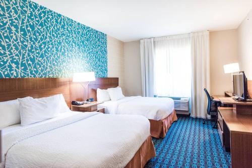 a hotel room with two beds and a tv at Fairfield Inn and Suites by Marriott Natchitoches in Natchitoches