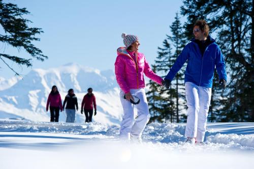 two people walking in the snow holding hands at Apartment Gästehaus Luggau in Rauris