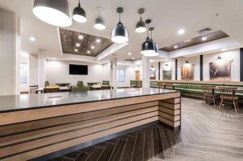 a lobby with a bar with chairs and tables at Fairfield by Marriott Inn & Suites Greensboro Coliseum Area in Greensboro