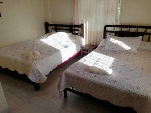 two beds sitting next to each other in a bedroom at Los Geranios Hospedaje in Tota