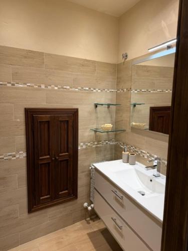 a bathroom with a sink and a mirror at PienzaLettings "Casa Olivieri" in Pienza