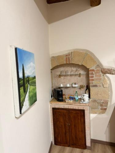 a kitchen with a painting on the wall next to a counter at PienzaLettings "Casa Olivieri" in Pienza