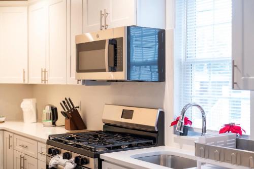 a kitchen with a stove and a microwave at 30-1 - 4BR Boston - Cozy Apt near Geneva Cliffs in Boston