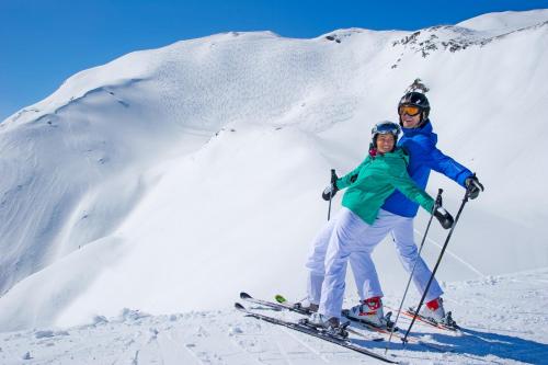 two people on skis on a snow covered mountain at Apartment Gästehaus Luggau in Rauris
