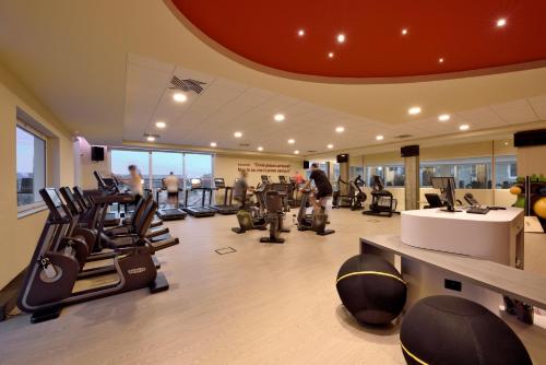 a gym with treadmills and exercise equipment in a building at Hotel Villa Glicini in Pinerolo