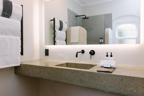 a bathroom with a sink and a mirror at Auberge Burgundy Boutique Hotel & Spa in Hermanus