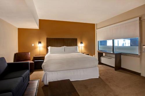 a hotel room with a bed and a couch at Four Points by Sheraton Peoria in Peoria