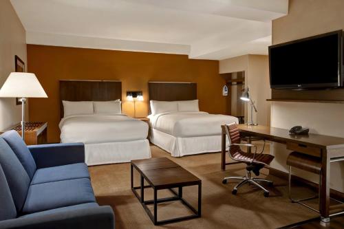 a hotel room with two beds and a desk at Four Points by Sheraton Peoria in Peoria