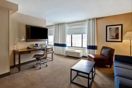 a hotel room with a desk and a computer and a chair at Four Points by Sheraton Peoria in Peoria