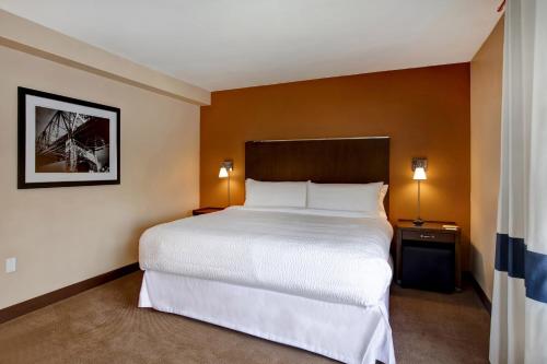 a hotel room with a large bed and two lamps at Four Points by Sheraton Peoria in Peoria