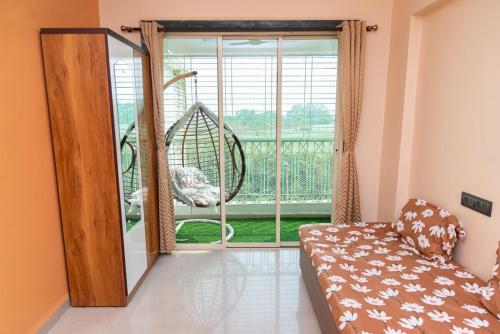 a living room with a couch and a large window at Teju's Nest in Badlapur