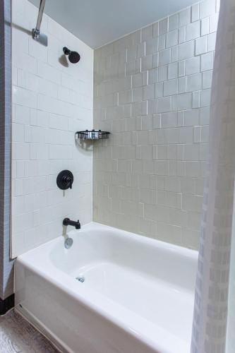 a bath tub in a bathroom with white tiles at Four Points by Sheraton Appleton in Appleton