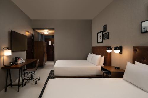 a hotel room with two beds and a desk at Four Points by Sheraton  in Punta Cana