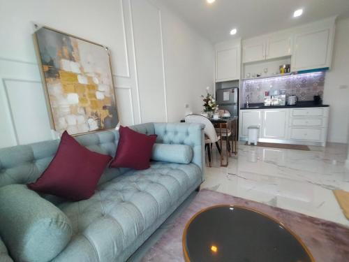 a living room with a blue couch and a table at The Empire Tower Jomtien KZi 2205 in Jomtien Beach