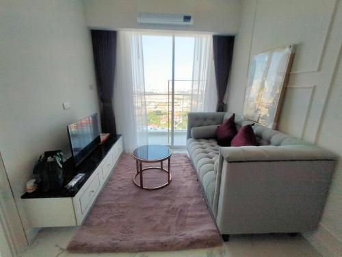 a living room with a couch and a tv at The Empire Tower Jomtien KZi 2205 in Jomtien Beach