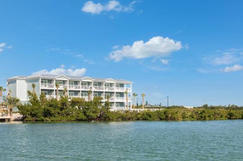 a large white building on the shore of a body of water at Fairfield by Marriott Inn & Suites Marathon Florida Keys in Marathon