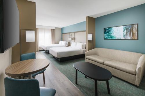 a hotel room with a bed and a couch and a table at Fairfield by Marriott Inn & Suites Marathon Florida Keys in Marathon