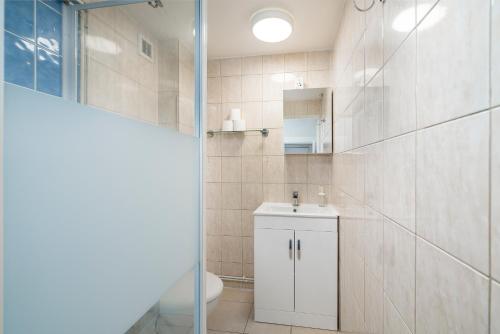 a bathroom with a sink and a toilet and a mirror at Modern 2Bed North London Flat by D3 Short Stay, Sleeps 6, Private Yard in London