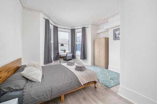 a bedroom with a bed and a table in it at Modern 2Bed North London Flat by D3 Short Stay, Sleeps 6, Private Yard in London
