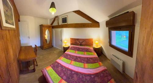 a bedroom with a bed and a tv in it at Gîte Des Prés Berthe in Le Clerjus