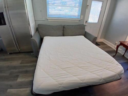 a large white bed in a room with a couch at Iguana Updated Home By Large Imperial River 1 Mi to Beach in Bonita Springs