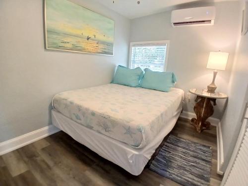 a small bedroom with a bed with blue pillows at Iguana Updated Home By Large Imperial River 1 Mi to Beach in Bonita Springs