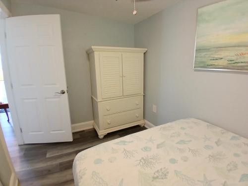 a bedroom with a bed and a white cabinet at Iguana Updated Home By Large Imperial River 1 Mi to Beach in Bonita Springs