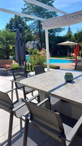 un patio avec une table et des chaises et une piscine dans l'établissement Villa avec piscine en Alsace, à Eschau