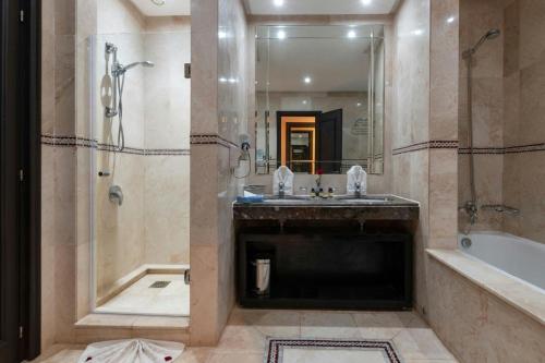 a bathroom with a sink and a shower and a tub at Eden Andalou Aquapark & Spa in Marrakech