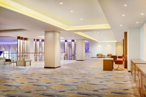 a lobby of a hotel with columns and chairs at Four Points by Sheraton Manado in Manado
