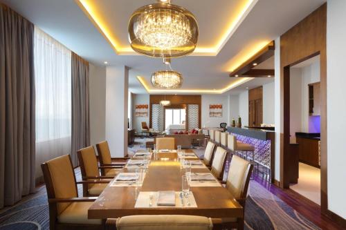 a long dining room with a long table and chairs at Four Points by Sheraton Manado in Manado