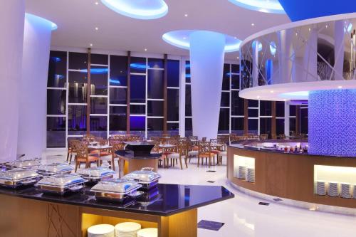 a restaurant with a bar and tables and chairs at Four Points by Sheraton Manado in Manado