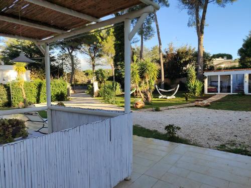 a backyard with a white fence and a porch at Villa don peppe in Selva di Fasano