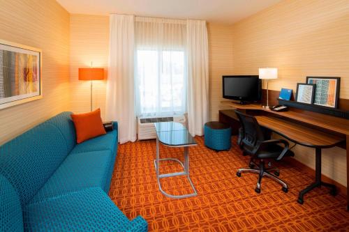 a hotel room with a couch and a desk with a computer at Fairfield Inn & Suites by Marriott Hershey Chocolate Avenue in Hershey