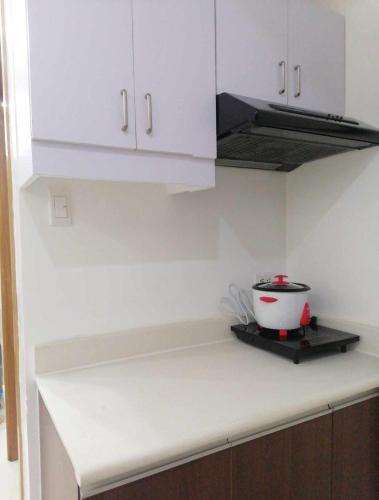 a kitchen with white cabinets and a bowl on a counter at Roxas Blvd Stunning Studio Condo Near US Embassy in Manila