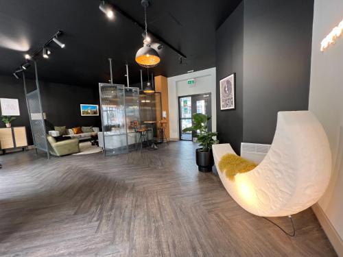 a living room with a white chair and a couch at Canvas The Old Fire Station Birmingham in Birmingham