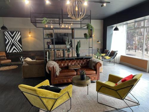a large living room with couches and chairs and a chandelier at Canvas The Old Fire Station Birmingham in Birmingham
