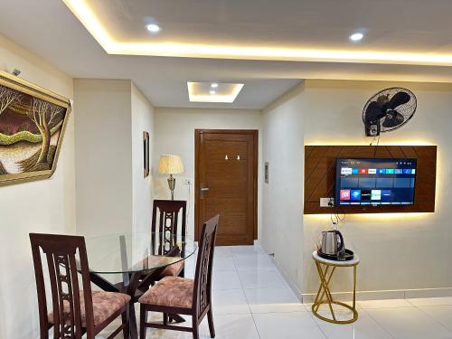a dining room with a glass table and chairs at Mukhtar Homes Bahria Town Lahore in Lahore