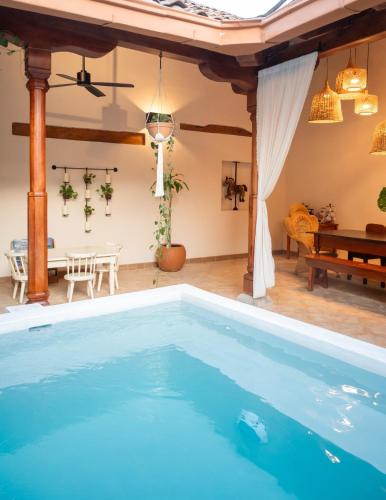 a large swimming pool in a living room with a table and a dining room at Central Park Luxurious Historical Home With Pool in Granada